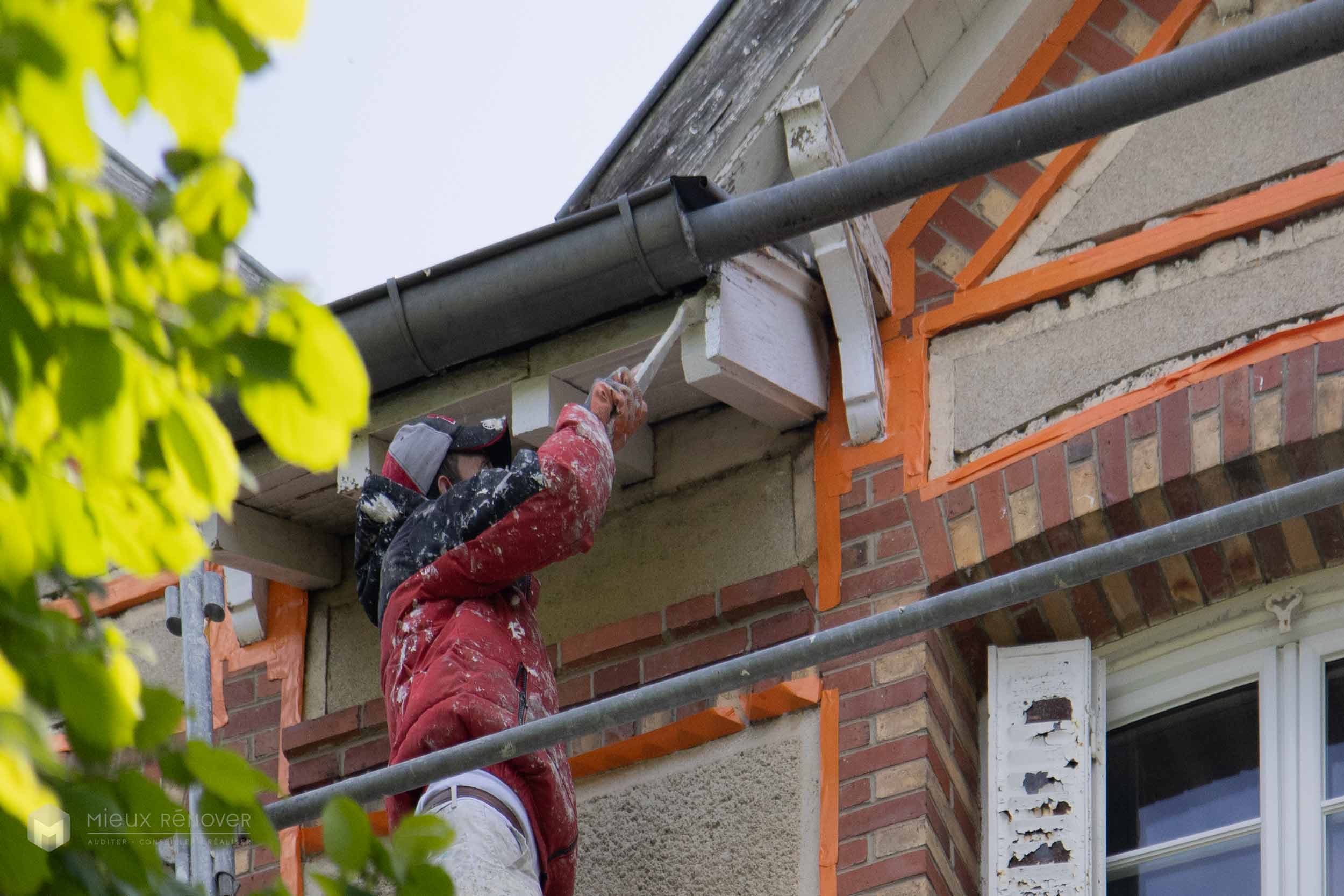 Application de peinture sur les voliges au cours d'un traitement de façade coloré à Samoreau